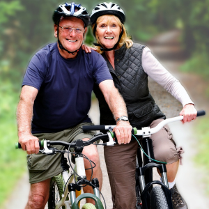 Supporting a Life of Shared Adventures A happy and healthy senior couple with gray hair smiling while riding bicycles outdoors, embodying vitality and an active lifestyle supported by Vital Procollagen.